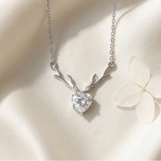 Silver necklace with heart-shaped pendant on a soft beige background